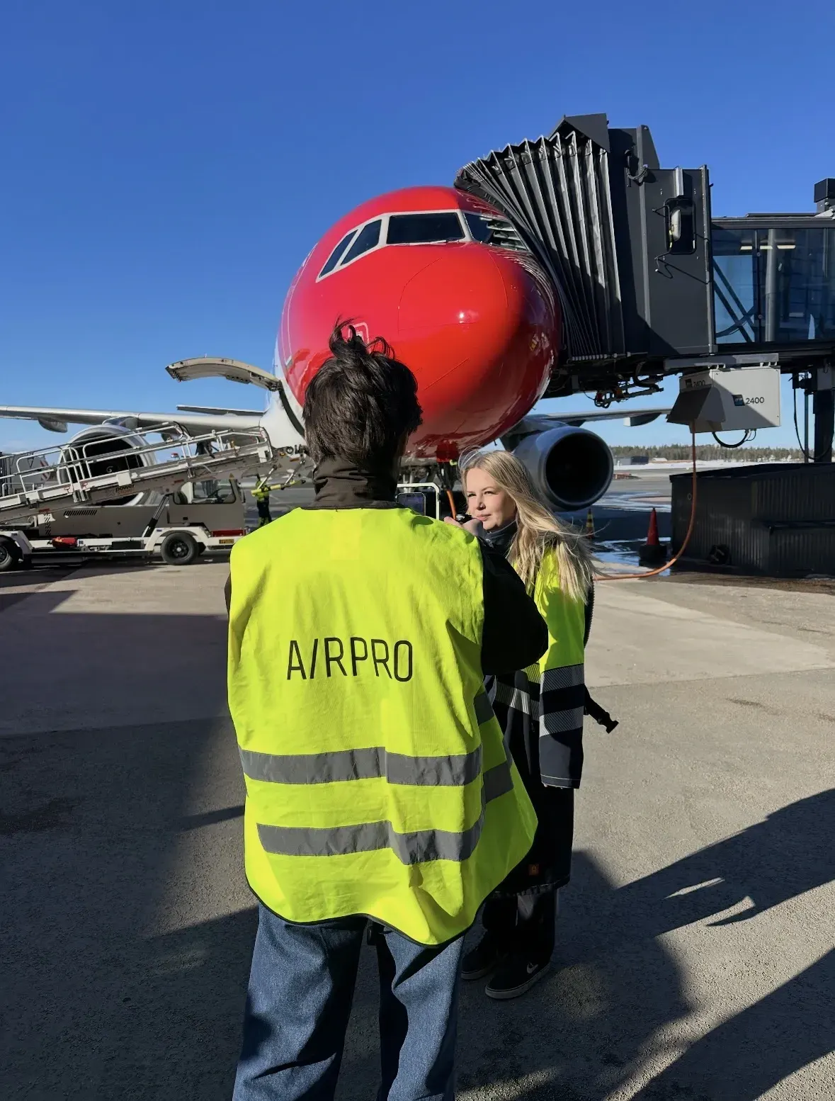 Airpron työntekijät huomioliiveissä lentokoneen edessä lentokentällä